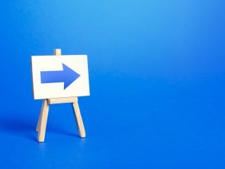 Easel with a blue right arrow. Sign of direction. Advertising of the location of a store or outlet.